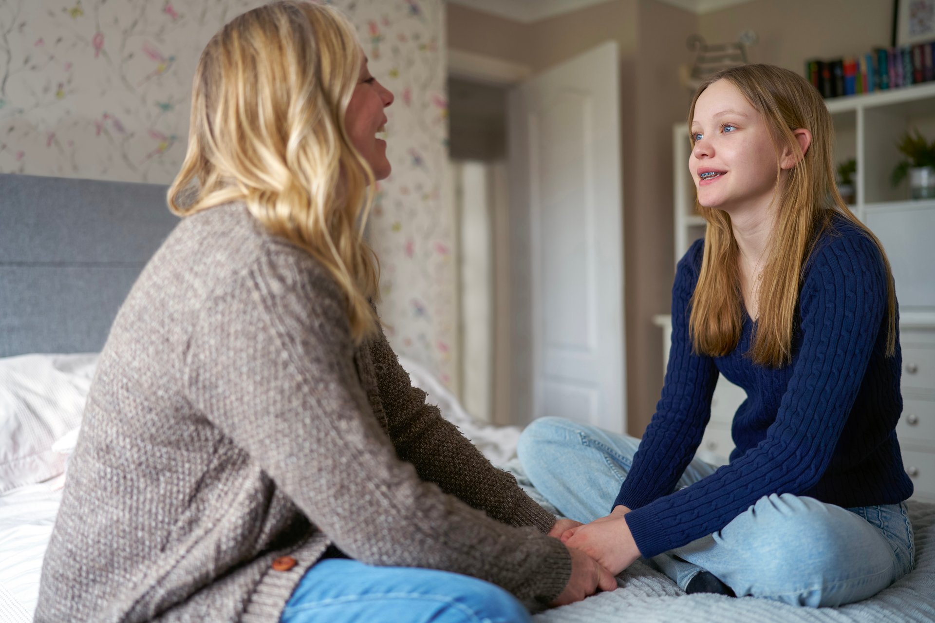 Mother and daughter talking and laughing together at home