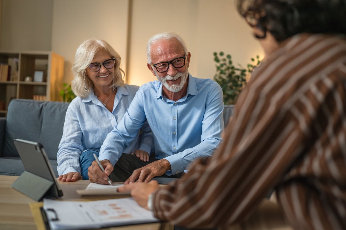 Senior couple reviewing financial documents with advisor