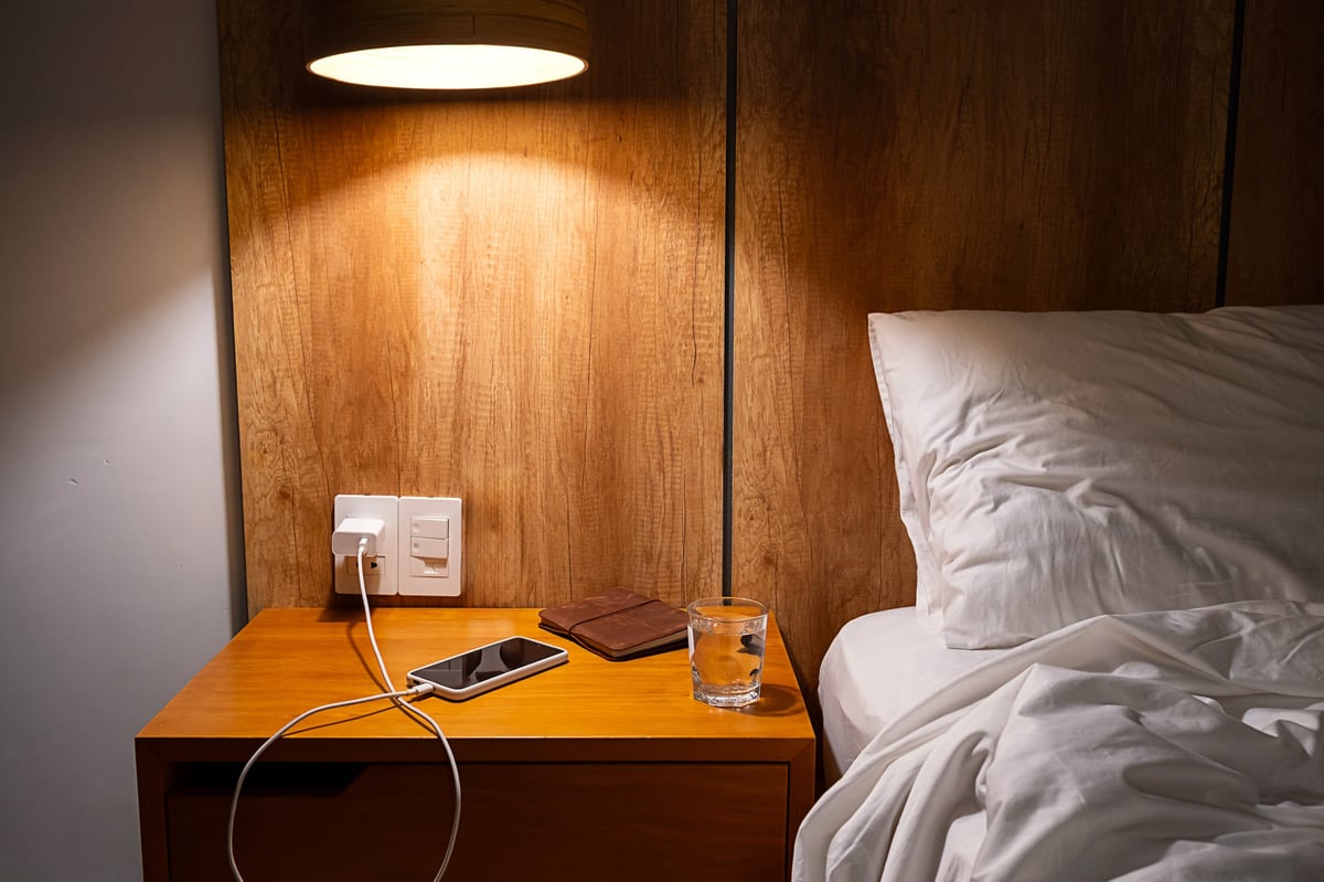 A cozy bedside setup with phone, water, and essentials within easy reach for nighttime safety