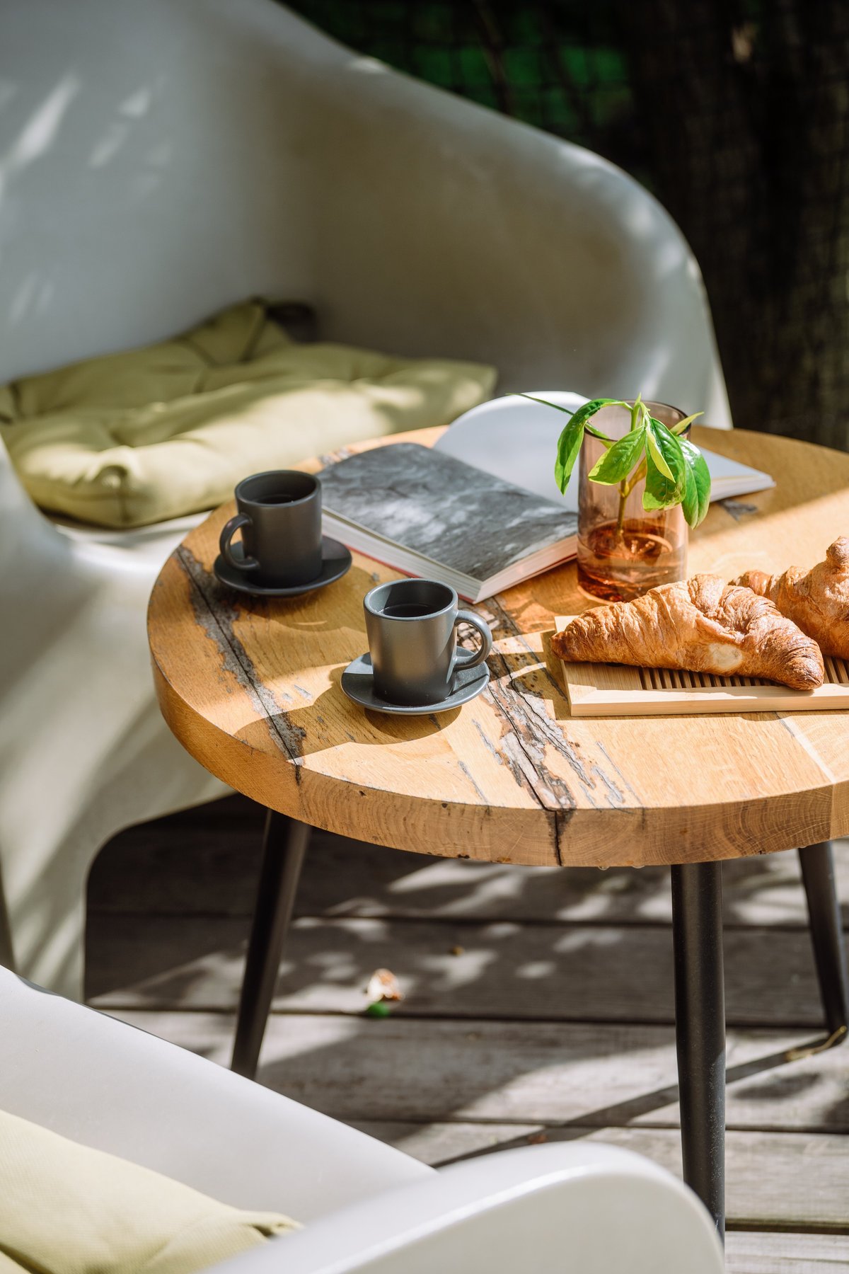 Morning brunch with espresso and fresh croissants on a wooden table, calm planning scene