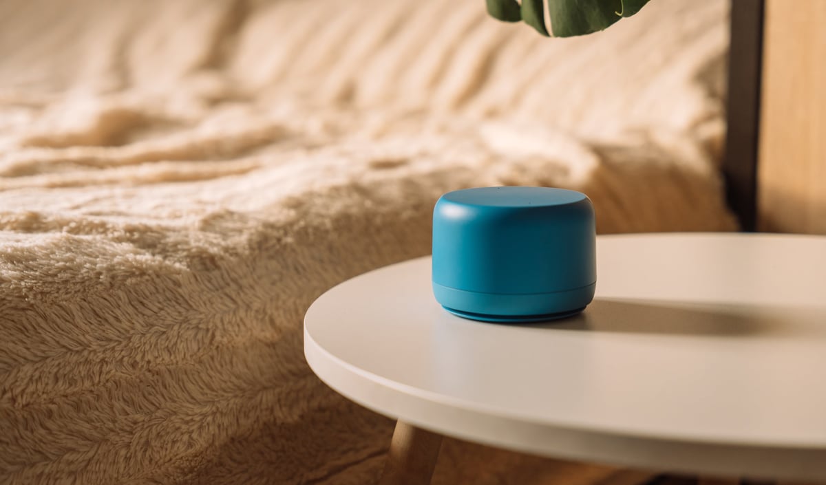 Minimal blue AI smart speaker on bedside table. High quality photo
