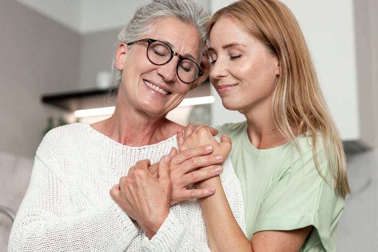 Elderly mother and daughter smiling and holding hands