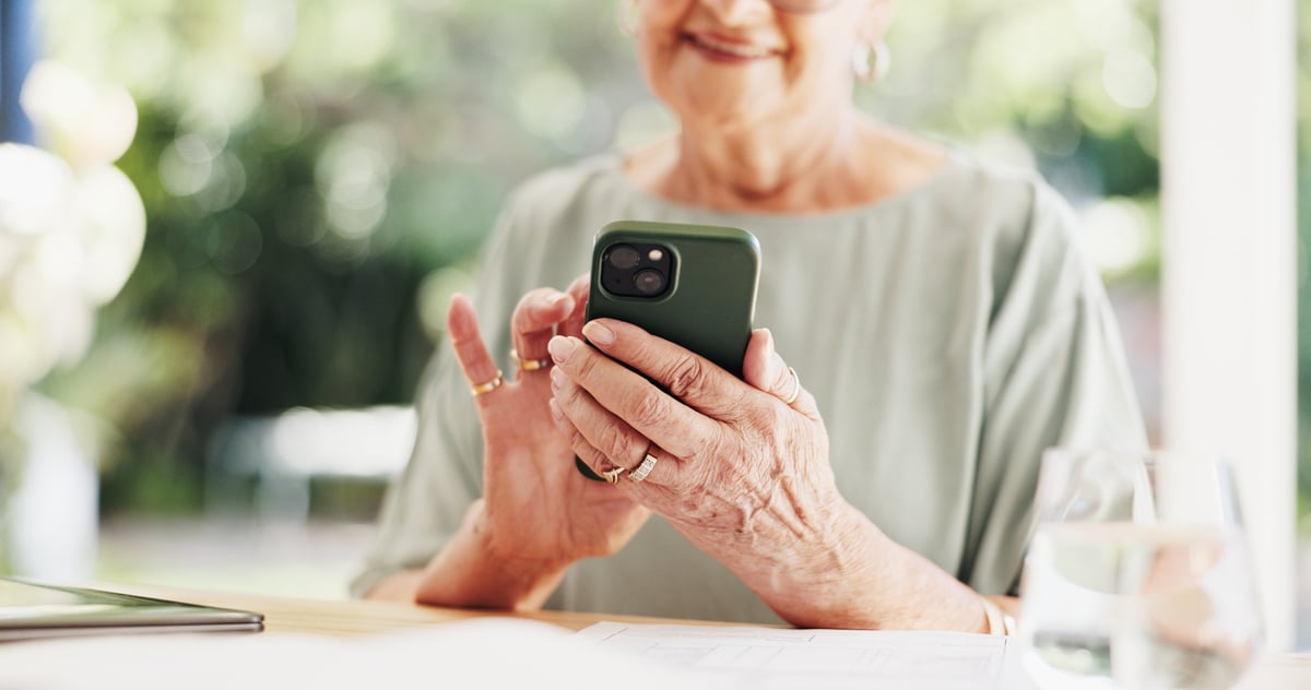 Phone, typing and smile with senior woman in home for social media, reading and online.